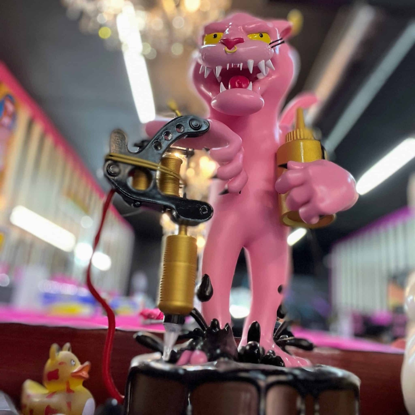 Koolsville Tattoo pink panther mascot holding a tattoo machine inside the Las Vegas shop